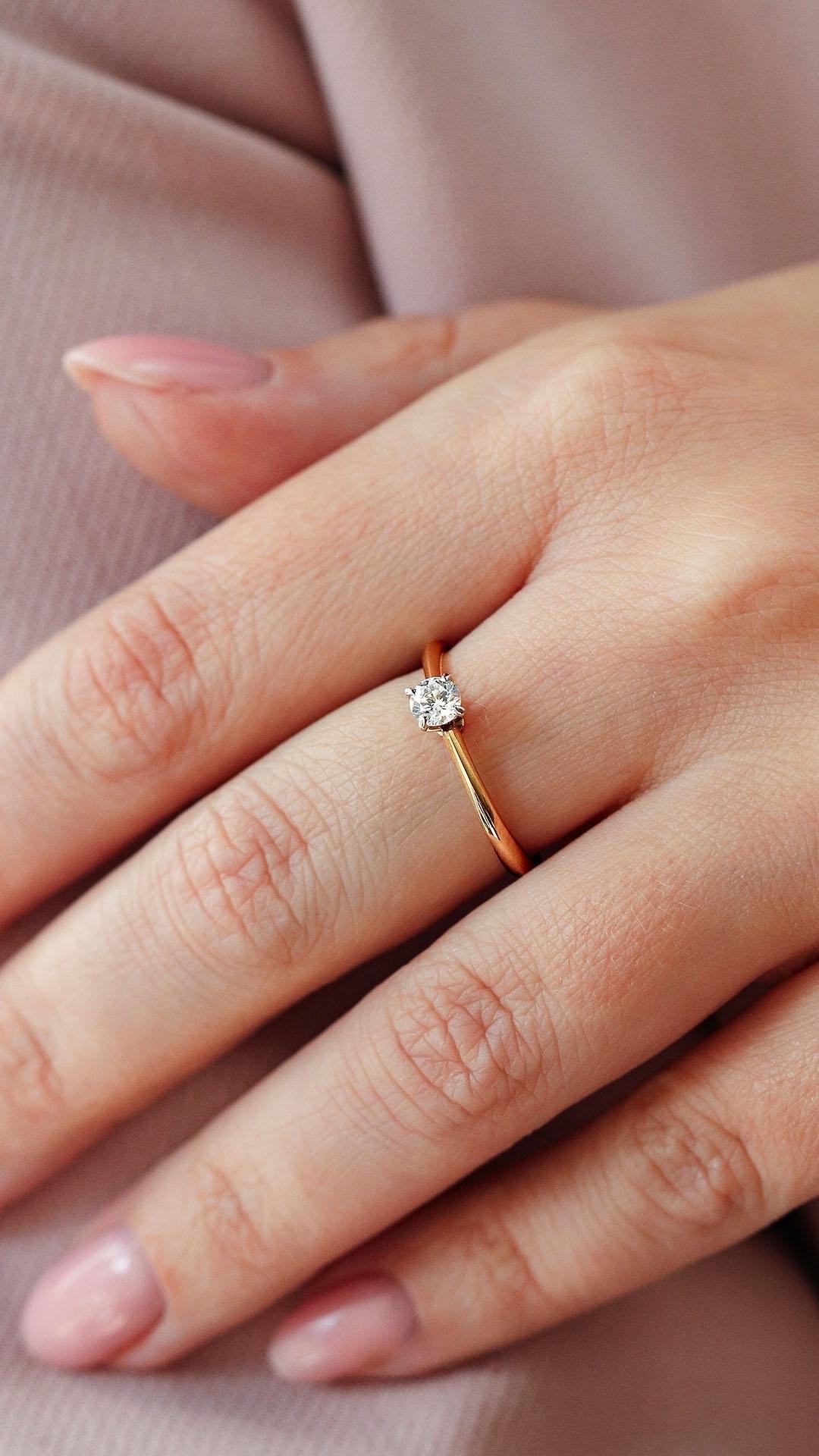 Pierscionek zareczynowy z szafir bialy 025 ct z zolte zloto angel na palcu 02